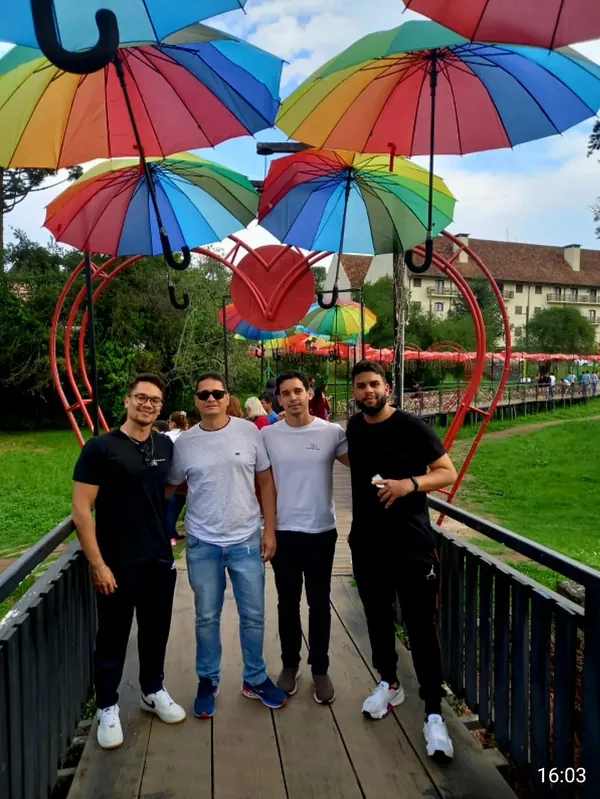 Grupo em passeio pelos jardins com guarda-chuvas coloridos