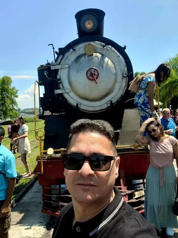 Viajante junto à locomotiva Maria Fumaça